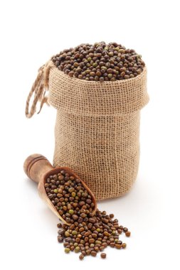 Organik Yeşil Gram 'a (Vigna radyatör) yakın plan veya tüm yeşil moong dalını parlatılmamış, jüt bir çantada ve kepçe üzerinde, beyaz bir arka planda izole edilmiş..