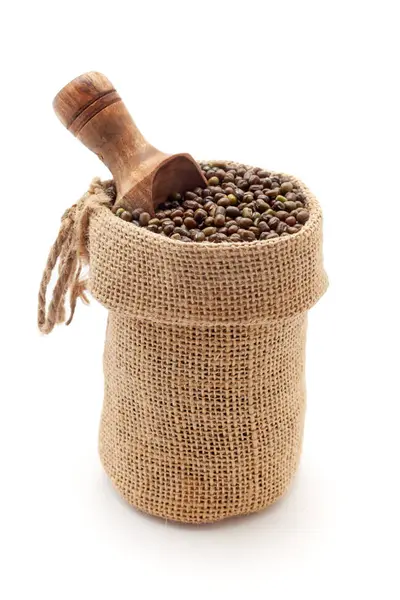 stock image Close-up of Organic whole Green Gram (Vigna radiata) or whole green moong dal unpolished, in a jute bag with a scoop, Isolated on a white background.