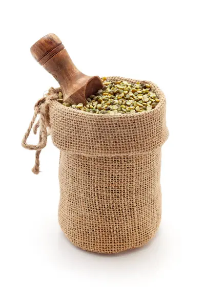 stock image Close-up of Organic Green Gram (Vigna radiata) or spilt green moong dal unpolished, in a jute bag with a scoop, Isolated on a white background.