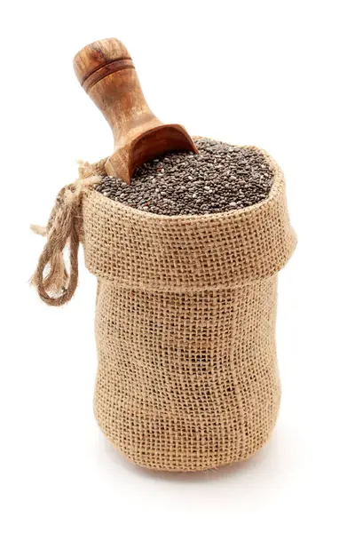 stock image Close-up of Organic Chia Seeds (salvia hispanica), in a jute bag with a scoop, Isolated on a white background.