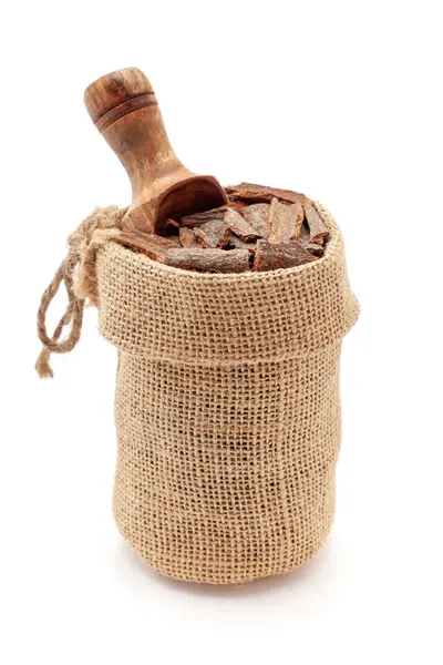 stock image Close-up of Organic Cinnamon sticks (Cinnamomum verum), in a jute bag with a scoop, Isolated on a white background.