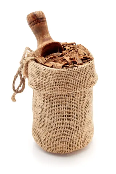 stock image Close-up of Organic Cinnamon sticks (Cinnamomum verum), in a jute bag with a scoop, Isolated on a white background.