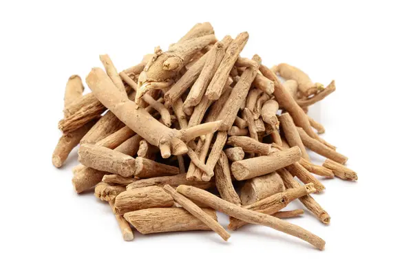Beyaz arka planda izole edilmiş kuru organik Ashwagandha (Withania somnifera) kökleri yığını. Ön görünüm