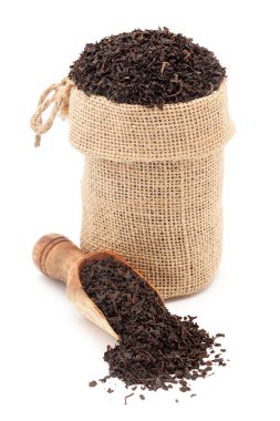 Kuru organik siyah Darjeeling çay yaprakları yakın çekim, bir jute çanta içinde ve bir kepçe üzerinde, beyaz arka planda izole.
