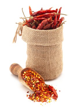 Kuru Organik Biber (Capsicum annuum) 'un tamamını bir jute torba içinde ve beyaz bir arka planda izole edilmiş bir kepçeyle Chili tanelerinin yakın plan çekimi..