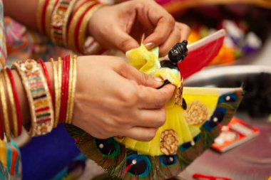 Hintli bir kadın Krishna Janmashtami festivali sırasında bir tören banyosu yaptıktan sonra Hindu tanrısı 'Krishna' yı (Laddu Gopal) süslüyor..