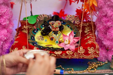 Hintli bir kadın Krishna Janmashtami festivali sırasında Hindu tanrısı Laddu Gopal 'a bir kase' Maakhan Misri 'sunuyor..