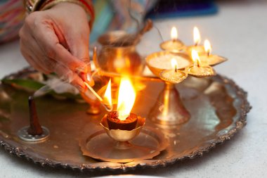 Pirinçten bir lambayla Puja veya Arti thali. Hintli bir kadın Hindu Tanrısına ibadet etmek için tütsü çubuğu yakıyor..