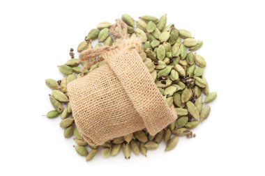 Close-up of organic Cardamom (Elettaria cardamomum) in a jute bag on a heap of cardamom, isolated on a white background. clipart