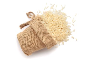 Org Anic White Rice 'ın (Oryza sativa) yakın plan çekimi, beyaz arka planda izole edilmiş bir jüt çantasından dökülür..
