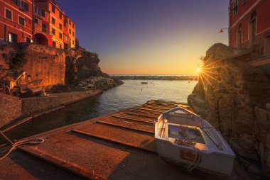 Riomaggiore village, a boat in front of the sea at sunset. Cinque Terre National Park, Liguria region, Italy, Europe.