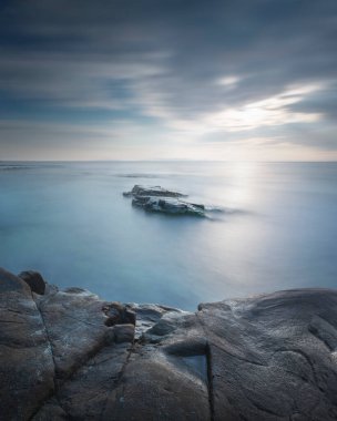 Denizde kayalar. Uzun pozlama fotoğrafı. Cala Violina, Toskana, İtalya.