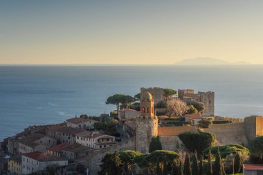Castiglione della Pescaia, arka planda eski kasaba ve deniz gün batımında. Maremma, Toskana bölgesi, İtalya, Avrupa