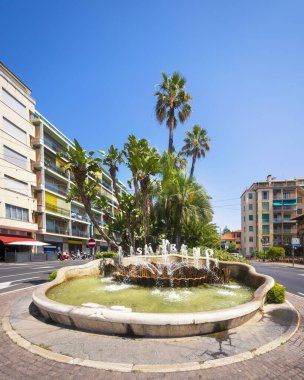 The famous fountain in the center of Sanremo, with the name of the city. Palm trees in the background clipart