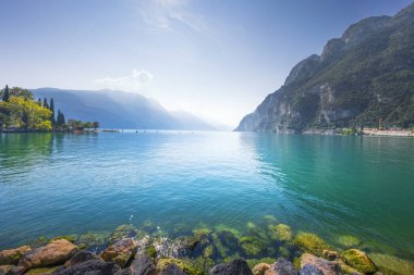 Riva del Garda 'dan Garda Gölü manzarası ve ön planda kayalar. Trentino bölgesi, İtalya, Avrupa.