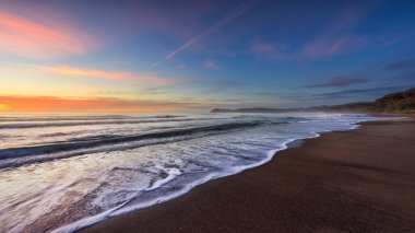 Gün batımında Baratti sahilinde dalgalar, panoramik manzara. Piombino, Alta Maremma, Toskana bölgesi, İtalya