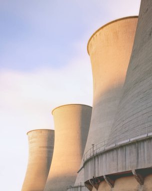 Gün batımında jeotermal santraldeki soğutma kuleleri. Larderello, Toskana bölgesi, İtalya. Jeotermal enerji bir alternatif ve sürdürülebilir enerji üretimidir..
