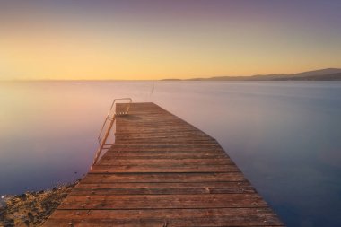 Günbatımında Trasimeno Gölü 'nde tahta iskele. Uzun pozlu fotoğrafçılık. Torricella, Magione, Perugia ili, Umbria bölgesi, İtalya