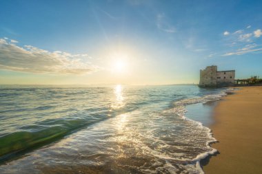 Torre Mozza beach and an old building on the sea. Follonica, Province of Grosseto, Tuscany region, Italy clipart