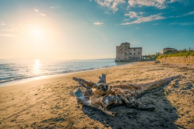 Torre Mozza beach and a trunk with an old building on the sea. Follonica, Province of Grosseto, Tuscany region, Italy clipart