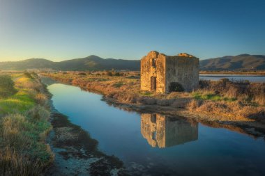 Castiglione della Pescaia gün batımında, Diaccia Botrona su kanalı ve bir harabe. Kuşların doğal rezervi. Toskana, İtalya, Avrupa.