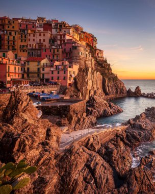 Manarola 'nın güzel balıkçı köyünün üzerinde gün batımı Cinque Terre Ulusal Parkı, Liguria bölgesi, İtalya ve Avrupa' da kayalıklarda..