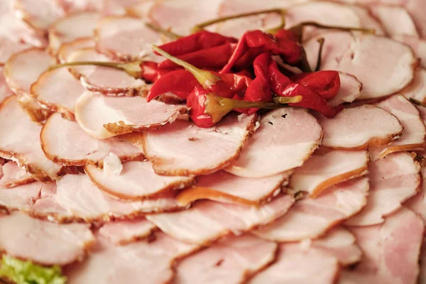 stock image Slices of ham and red chili peppers. Luncheon meat platter, cold cuts