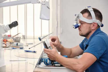 Diş teknisyeni, diş laboratuarında eklem makinesi ile çalışıyor. Protez ve implantoloji kavramı.