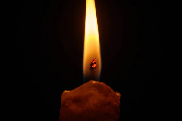 Closeup of burning candle isolated on black background. Melted Wax Candles Burning at Night.
