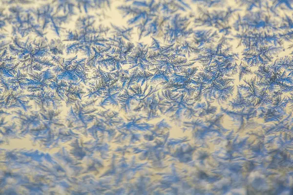 Buz desenleri: Soyut Buz oluşumları Bir Pencere üzerinde. Donuk desenler ve sıcak arkaplan arasındaki kontrastı vurgulayan ayrıntılı çekim.