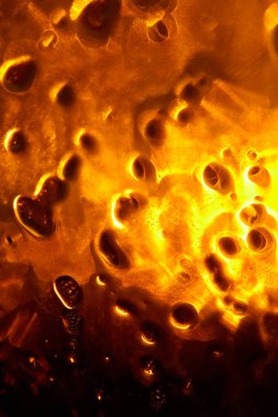 Kabarcıkları ve kusurları olan saydam altın bir maddenin soyut yakın çekimi güzel ve gizemli bir görüntü yaratır. Soyut Altın Sıvı: Eşsiz bir doku.