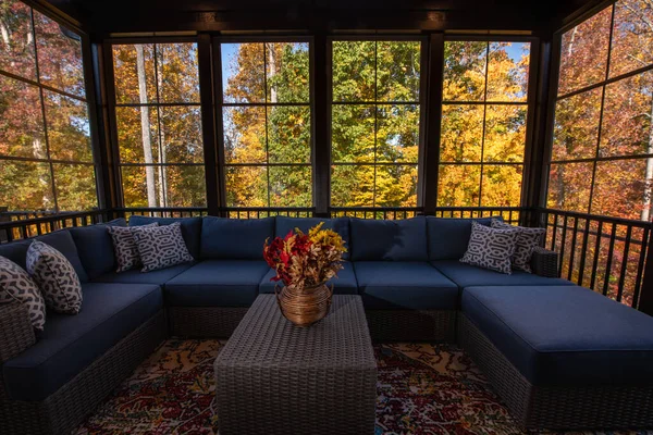 感恩节的时候 舒适的门廊上挂着现代家具 花瓶中的花朵 背景中的秋叶和树林 — 图库照片