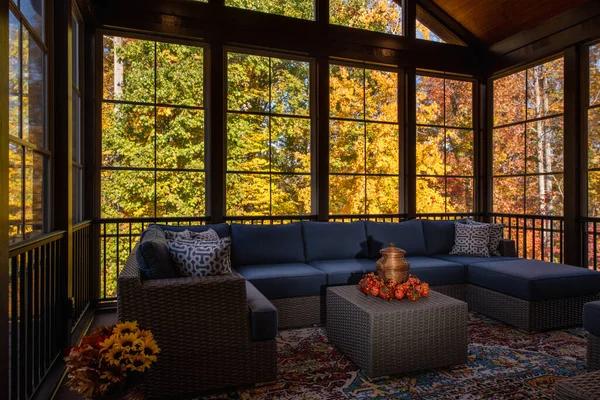 感恩节的时候 舒适的门廊上挂着现代家具 花瓶中的花朵 背景中的秋叶和树林 — 图库照片