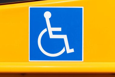 Sarı bir okul otobüsüne engelli tekerlekli sandalye girişi logosu..