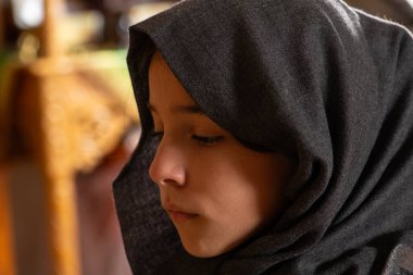 Dua eden genç bir kızın yakın portresi..