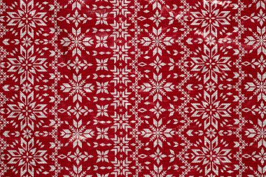 Kırmızı arka planda beyaz kar taneleri buruşmuş ambalaj kağıdı. Noel Tatili Konsepti.