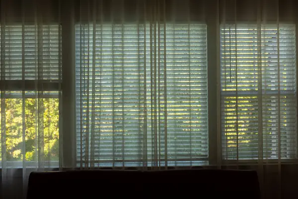 Looking outside through curtains and window blinds. Element of design.