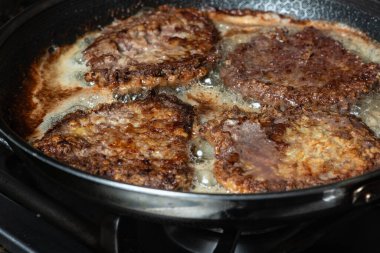 Tavada şnitzel kızartıyorum. Ev yemeği konsepti.