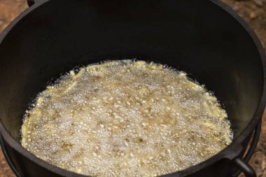 Kızarmış patatesi ya da patates kızartmasını siyah bir tencerede yakından izle. Parti konsepti için yemek servisi.