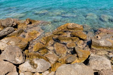 Kayalık plajlı deniz manzarası, mavi berrak su.