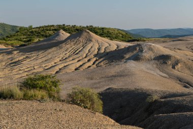 Romanya 'nın Buzau kenti Berca yakınlarındaki çorak arazide nadir görülen bir Avrupa jeolojik fenomeni sergileniyor. Burada, Dünya 'dan gelen gazlar tepelerin arasından çıkar, küçük çamur volkanları oluşturur ve kendine özgü ve dikkat çekici bir manzara oluşturur..