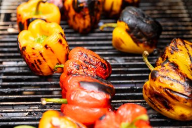 Barbekü şöminesinde kırmızı ve sarı ızgara biber..