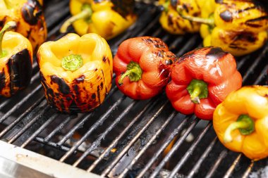 Barbekü şöminesinde kırmızı ve sarı ızgara biber..