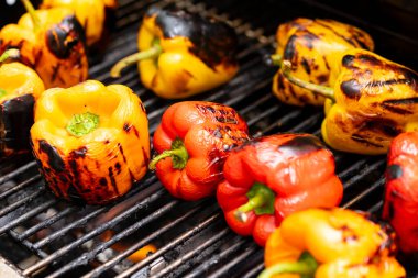 Barbekü şöminesinde kırmızı ve sarı ızgara biber..
