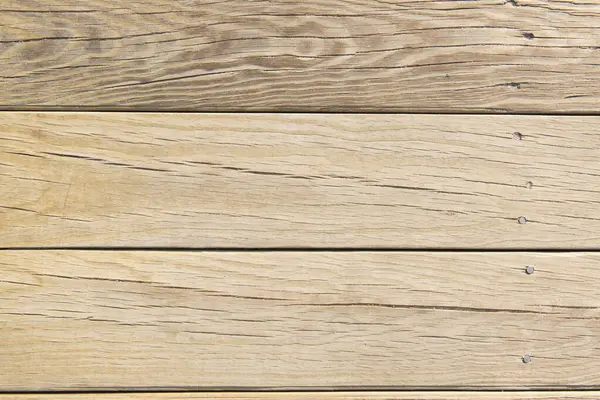 stock image A clean wooden deck with light traces of sand. The natural wood grain and soft sand create a calm, earthy aesthetic, ideal for use as a background or texture.