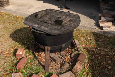 Güney Carolina, Charleston 'daki Middleton Place Çiftliği' nde tahta kapaklı bir kırsal demir tencere güneş altında duruyor..