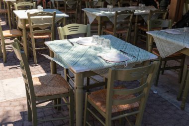 Yunanistan 'ın Zakynthos kentindeki misafirler için geleneksel Yunan taverna masası tabaklar ve cam örtülerle gölgelenmiş ve hazır.