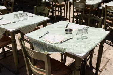 Yunanistan 'ın Zakynthos kentindeki misafirler için geleneksel Yunan taverna masası tabaklar ve cam örtülerle gölgelenmiş ve hazır.
