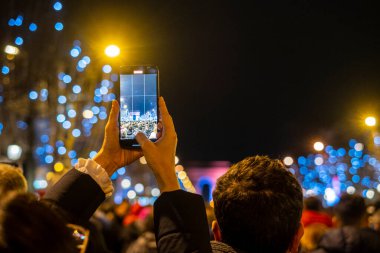 Paris 'teki Zafer Takı' nda cep telefonlarıyla fotoğraf çeken turistler, yeni yıl arifesi fotoğrafçılığı. Paris sokaklarında kutlamalar.