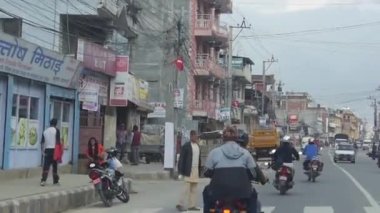 Yoldaki arabalar ve motorsikletlerle çevrili. Soldan Sağa Sonra İleri Kaydır